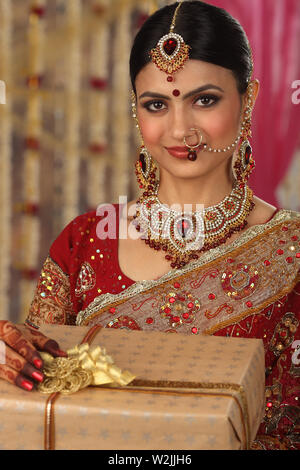 Indian bride holding gift boxes and smiling Stock Photo