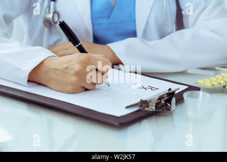 Doctor woman filling up prescription, close-up of hands. Physician at work. Medicine and healthcare concept Stock Photo