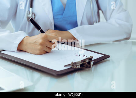 Doctor woman filling up prescription, close-up of hands. Physician at work. Medicine and healthcare concept Stock Photo