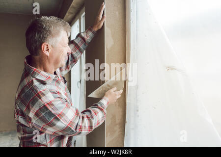 Diligent plasterer working on a window opening Stock Photo