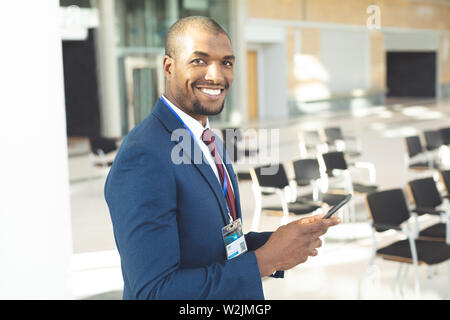 African-american male executive standing in conference room with smartphone Stock Photo