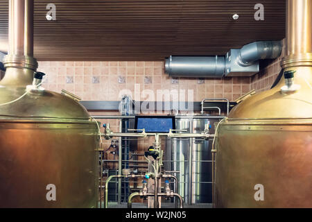 Close up of tanks and equipments in modern interior of brewery. Manufacturable process of brewage. Tanks and tubes in an up-to-date brewery. Mode and Stock Photo