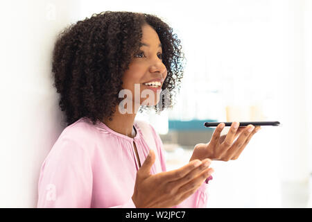Young pretty African-american employee talking on phone Stock Photo