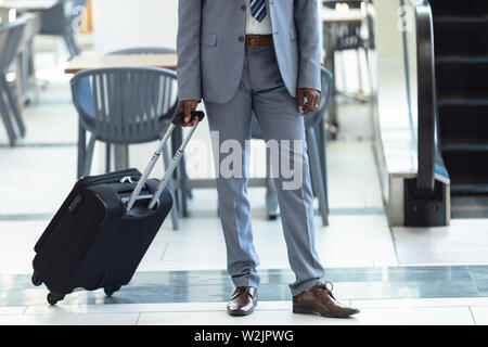 Young African-american executive standing with suitcase Stock Photo