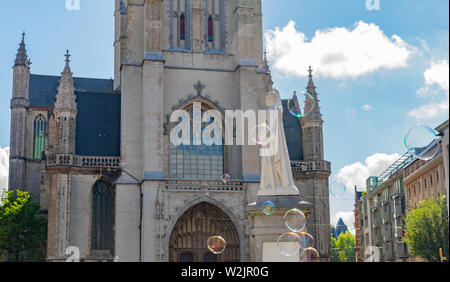 Big soap bubbles in air with white sculpture and  Saint Bavo  Cathedral  in  the background  in Ghent, Belgium Stock Photo