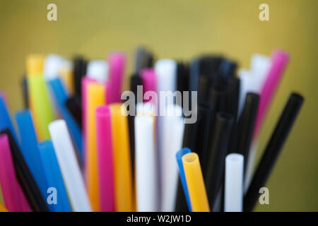 Closeup of multicolored plastic cocktail tubes on blurred background Stock Photo
