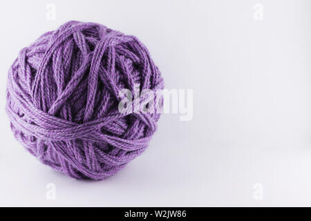 A large ball of violet wool. Cozy accessories. Materials for knitting. Stock Photo