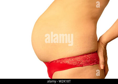 Pregnancy after 40 years concept. Older pregnant woman belly close up image on isolated background. Aged hands with wrinkles and sagging skin Stock Photo