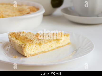 delicious fresh cottage cheese pie with shortbread and tea utensils on the table Stock Photo
