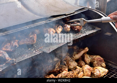 Barbecuing chicken pieces on oil drum barbecue at Bristol St Pauls  Carnival festival Stock Photo