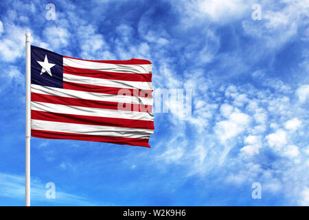 National flag of Liberia on a flagpole in front of blue sky Stock Photo