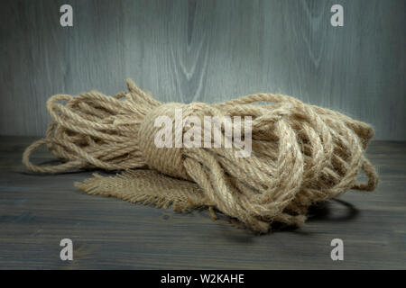 Twisted burlap jute twine rope in close-up on grey rustic background Stock Photo
