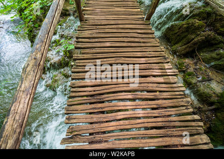 An elevated walkway made of wooden planks leading through the Plitvice Lakes National Park, Croatia Stock Photo