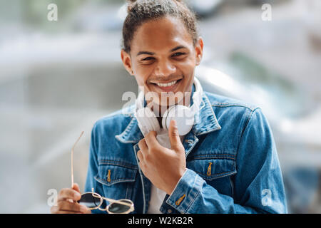 Facial expressions. Kind dark-skinned male person feeling happiness and looking aside Stock Photo