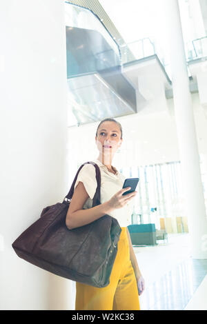 Female executive looking away while standing in modern office Stock Photo
