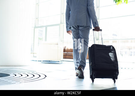 Young African-american male executive walking with suitcase Stock Photo