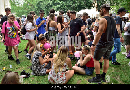 People all ages sitting, standing “hanging about” at summer Bristol St Pauls  Carnival festival, Brunswick Square, UK Stock Photo