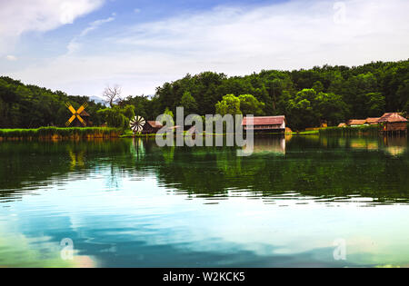 Landscape panorama with windmills and lake Stock Photo