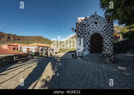 Cozy mountain village hiding in a quiet, deep gorge surrounded by gardens and subtropical forests on a paradise island. Beautiful warm sunny day. Trav Stock Photo