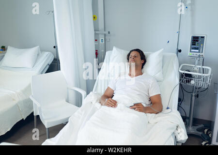 Male patient relaxing on bed in the ward at hospital Stock Photo