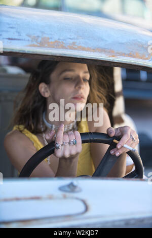 an attrrative young white woman in a car with a cigarette Stock Photo