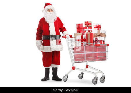 Full length portrait of santa claus standing with presents in a shopping cart isolated on white background Stock Photo