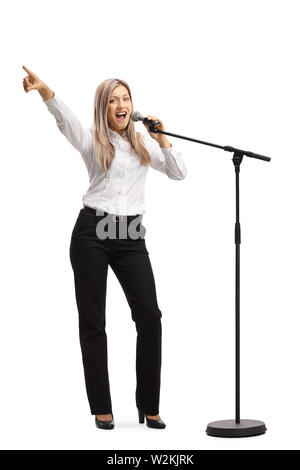 Full length portrait of a young blond woman with a microphone gesturing with finger isolated on white background Stock Photo