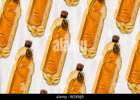 Plastic bottles on a white background. Composition from plastic brown bottles. The sun is shining, hard shadow of objects. Stock Photo