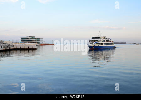 Pleasure boat approaching the pier on Baku Boulevard in the evening Stock Photo