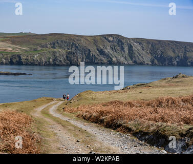 Track road on Calf Of Man with two people walking in the distance Stock Photo