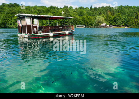 View of one of the ferries operating at the Plitvice Lakes National Park cruising on Jezero Kozjak, Lake Kozjak, and approaches the landing site Stock Photo
