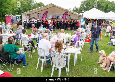 Crowd of seated people watching a choir perform at the main marquee at Stockton Heath Festival 2019 Stock Photo