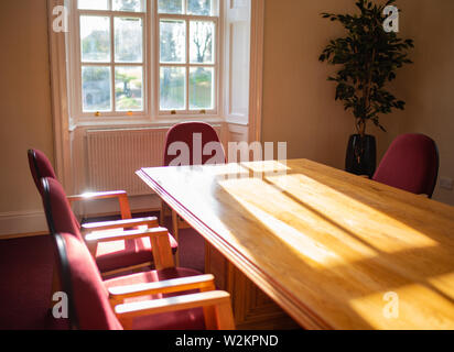 Empty conference room with sun shining through window, old building Stock Photo