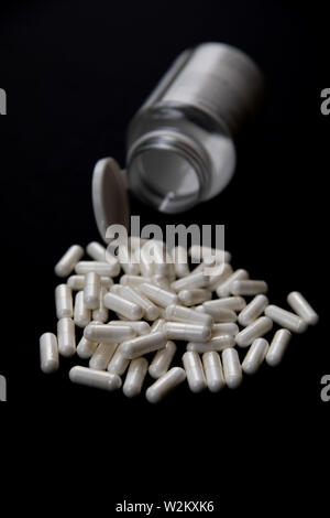white pills on black background. medical pharmacy supplements Stock Photo