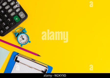 Alarm clock wakeup calculator pencil clipboard notepad color background Stock Photo