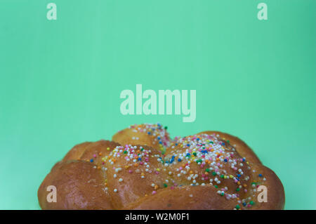 Close-up of a candy with colorful decoration on a green background where there is space to write texts or add graphics. Copy Text Stock Photo