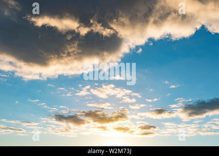 after rainstorm, rays of lights, dark clouds, heavy rain, bad weather. Beautiful sunlight passing through a big black rain cloud. Sunset in the sky Stock Photo
