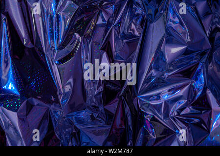 The background of crumpled holographic packaging film with an abstract pattern. Stock Photo