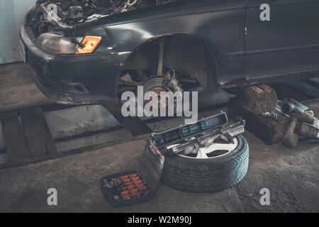 Car service. replace tires on wheels. Tire installation concept. old car is disassembled in the garage on the pit Stock Photo