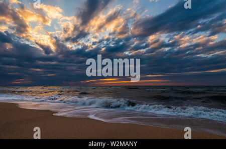 Beach with waves at colorful sunset Stock Photo
