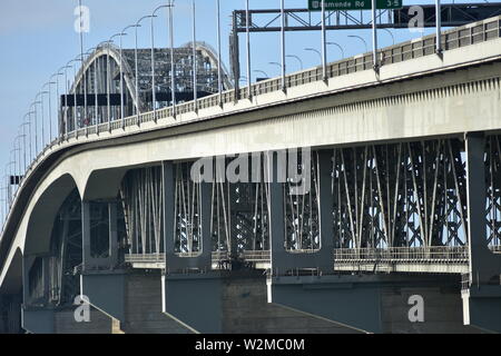 Auckland Harbour Bridge is motorway bridge of steel structure on concrete pylons connecting Auckland CBD with North Shore City. Stock Photo