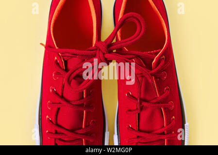 New red sneakers on yellow background with copy space. Stock Photo