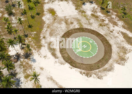 Helipad on a tropical island. Balabac, Palawan, Philippines. Helipad among the palm trees on a tropical island, top view. Stock Photo