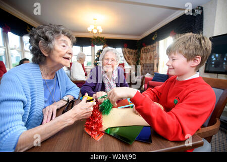 Schoolchildren in the Bristol area visit care homes to make Christmas decorations with residents in a programme organised by the charity Alive Activit Stock Photo