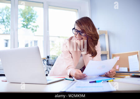 Businesswoman doing paperwork at office Stock Photo