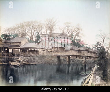 [ 1890s Japan - Asakusa District, Tokyo ] —   Imadobashi Bridge spanning the Sanyabori canal in the Asakusa district of Tokyo.  In the back is Matsuchiyama, a small hill on the west side of the Sumida River.   On top, Honryuin Temple can be seen. Locally known as Matsuchiyama Shoden, it is a sub temple of Sensoji and dedicated to Bishamonten, one of the Seven Gods of Good Luck.  19th century vintage albumen photograph. Stock Photo