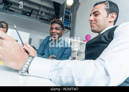 Working process. Young businessmen of different nationalities at the meeting. Stock Photo