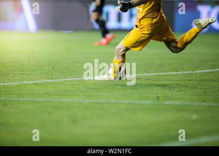 Details with the feet of a soccer goalkeeper kicking the ball during a match Stock Photo