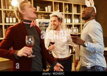 Friends celebrate hilariously and drunk the bachelor party in a bar Stock Photo