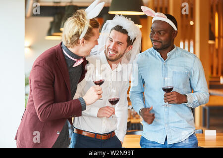 Friends in funny disguise celebrate a bachelor party in a bar Stock Photo